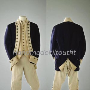 May include: A navy blue and cream-colored historical costume, including a jacket, vest, and pants. The jacket has cream-colored lapels and cuffs with decorative buttons. The pants are cream-colored. The outfit is displayed on a mannequin.