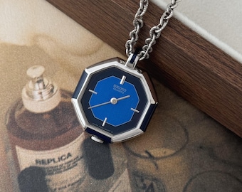 Reloj Seiko vintage con colgante octagonal en tono plateado y azul, con cadena, unisex.