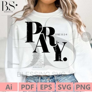 May include: A white t-shirt with a black graphic that says "PRAY" with a distressed font. The graphic also includes the Bible verse "LUKE 11:2-4".