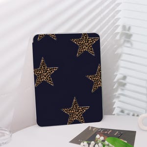 Può includere: Una custodia blu navy con un motivo a stella con stampa leopardata. La custodia è realizzata in materiale plastico rigido e ha una finitura liscia.