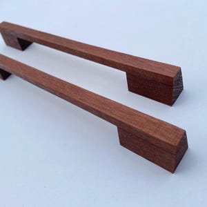 Op de afbeelding: Een set van drie keramische nestkommen in blauwe, groene en witte tinten. De kommen hebben een gespikkelde glazuur en een eenvoudig, modern ontwerp. De grootste kom heeft een diameter van ongeveer 15 cm.