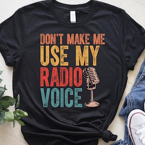 May include: Black t-shirt with a vintage-style graphic that says "Don't make me use my radio voice" with a retro microphone illustration.