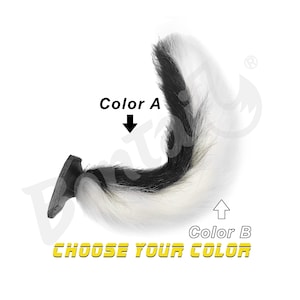 May include: A black and white faux fur tail with a black base. The text "Color A" and "Color B" are displayed with arrows pointing to the tail. The words "CHOOSE YOUR COLOR" are in yellow.