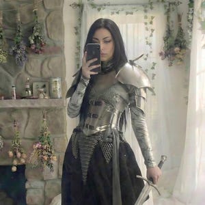 Female knight wearing steel corset armor with chainmail, pauldrons and bracers for Renaissance Faire fantasy cosplay