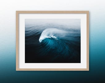 May include: A photograph of a large wave breaking in the ocean. The wave is a deep blue color and the water is a dark blue. The wave is breaking in a way that makes it look like a giant hand reaching up from the water.