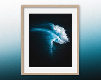 May include: A photograph of a large wave breaking in the ocean. The wave is a deep blue color and is lit by the sun, creating a bright white crest. The water is dark blue and the background is black.