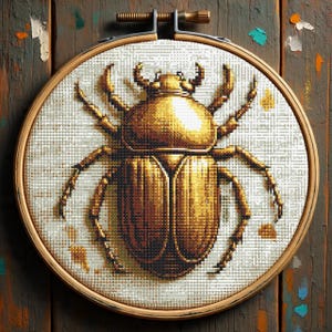 May include: A cross-stitch embroidery of a golden beetle, set in a wooden hoop. The beetle is detailed with various shades of gold and brown, set against a white background. The wooden hoop is held by a metal and brass mechanism. The background is a wooden surface.