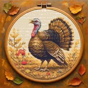 May include: A cross-stitch embroidery of a turkey in a wooden hoop. The turkey is brown, with a red wattle and a blue head. The background features autumn foliage and leaves in shades of yellow, orange, and brown.