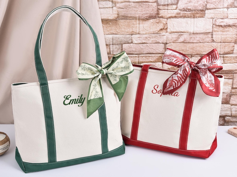 May include: Two canvas tote bags, one white with green trim and the name "Emily" embroidered in green, the other white with red trim and the name "Sophia" embroidered in red. Both bags have decorative bows.