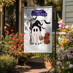 May include: White Halloween garden flag with a cartoon ghost in a witch's hat, holding a broom and a jack-o'-lantern. The flag also features bats, a spider web, and the words "Happy Halloween" in purple.