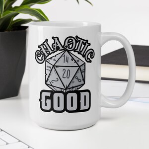 May include: White ceramic coffee mug featuring a black and grey graphic of a twenty-sided die and the text "Chaotic Good".