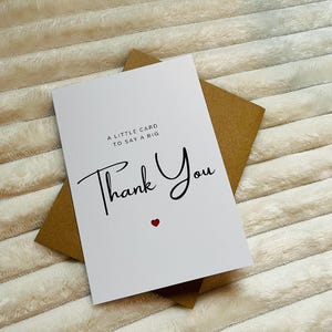 May include: A white card with a brown envelope. The card says "A little card to say a big Thank You" with a small red heart.