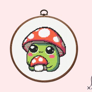 May include: A cross-stitch pattern of a cute green mushroom character with a red and white mushroom cap, holding a smaller red and white mushroom.