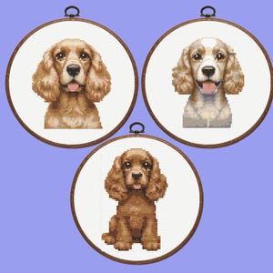 May include: Three framed cross-stitch portraits of Cocker Spaniels. The top two are headshots, one with a light brown coat and the other with a white and light brown coat. The bottom portrait shows a seated dog with a brown coat.