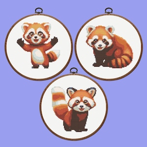 Puede incluir: Tres aros de bordado con diseños de panda rojo. Los aros son de madera con un acabado marrón. Los pandas rojos se representan en diferentes poses, incluyendo de pie, sentados y tumbados.
