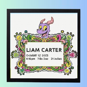 May include: Framed cross-stitch featuring a purple dragon character above a name and birth details. The text reads "LIAM CARTER" with the birth date, time, weight, and height of 21 inches.