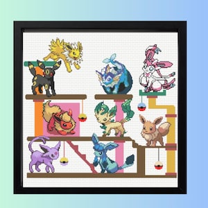 Könnte beinhalten: Ein gerahmtes Kreuzstichbild mit verschiedenen bunten Pokémon-Charakteren. Das Kunstwerk zeigt mehrere Kreaturen, darunter Jolteon, Umbreon, Vaporeon, Sylveon, Flareon, Leafeon, Eevee, Espeon und Glaceon, die auf einer mehrstöckigen Struktur angeordnet sind.
