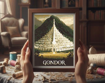 May include: A framed cross-stitch depicting Gondor, a city from a fantasy setting, with a mountain backdrop. The artwork is in a brown wooden frame. The word "GONDOR" is stitched at the bottom. The image is held by hands.