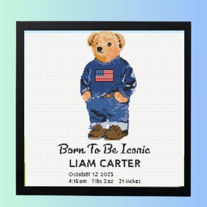May include: Cross-stitch artwork of a teddy bear wearing a blue sweater with an American flag and blue jeans. The framed art includes the text "Born To Be Iconic" and the name "LIAM CARTER". Additional text includes the date, time, weight, and height.
