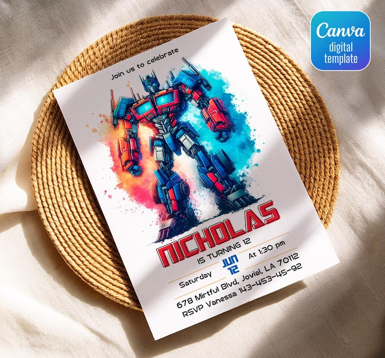May include: A white invitation card featuring a colorful illustration of a robot character. The card includes the text "Join us to celebrate" and details for a birthday party, including the name "Nicholas", date, time, and location. The card is on a woven placemat.