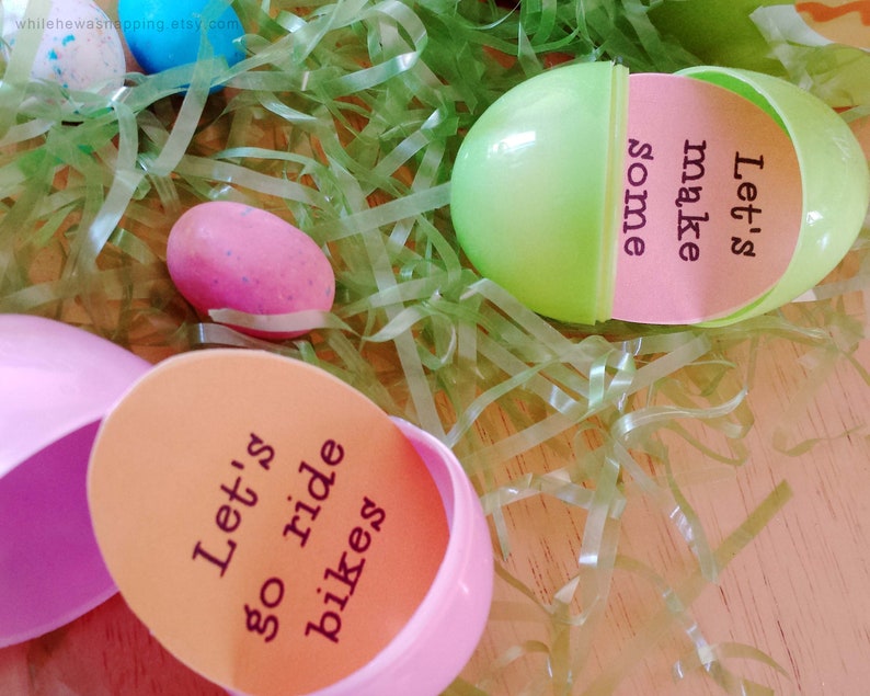 May include: Two plastic Easter eggs with messages inside. One egg is pink and says "Let's go ride bikes". The other egg is green and says "Let's make some".