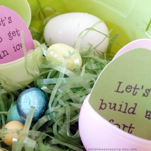 May include: Pink and green plastic Easter eggs with paper inserts that read "Let's go get an ice cream" and "Let's build a fort". The eggs are nestled in green shredded paper.