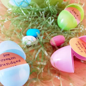May include: Plastic Easter eggs with different messages inside. The messages include "Let's go ride", "Let's make", "Ice cream sundaes", and "Let's go pizza". The eggs are sitting on a bed of green grass.