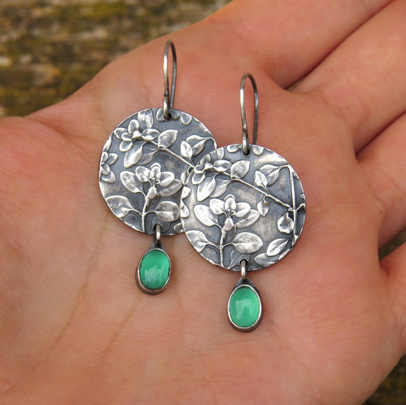 Puede incluir: Pendientes de plata con dise&ntilde;o floral y gotas de piedras preciosas verdes.