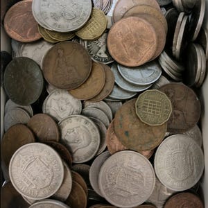May include: A close-up of a collection of antique coins, including silver Half Crowns and copper pennies. The coins are of various sizes and colours, some showing signs of age. The assortment includes coins with different designs and inscriptions.