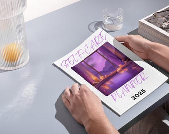 May include: A white self-care planner with a purple illustration of a room with a window overlooking a purple sunset and candles. The text "SELF-CARE PLANNER 2025" is written in purple on the cover.