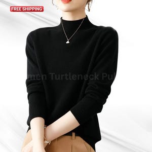May include: A black turtleneck jumper with long sleeves. The jumper has a ribbed collar and cuffs. The text "men Turtleneck Pu" is visible on the jumper. A gold necklace is worn with the jumper.