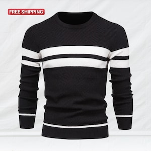 May include: Black and white striped sweater. The long-sleeved sweater features a crew neck and a textured knit pattern. Two wide white stripes are across the chest. The sweater has a ribbed hem and cuffs. The text "FREE SHIPPING" is in a red box in the upper left corner.