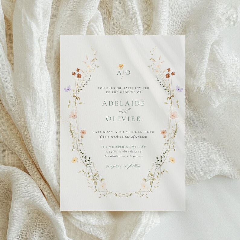 May include: A wedding invitation with floral detailing. The invitation includes the names "Adelaide and Olivier" and event information. The text is surrounded by a delicate floral border with pastel flowers and greenery. The background is a soft, off-white colour.