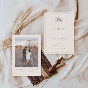 以下が含まれることがあります： 写真と「Save the Date」カードが特徴のウェディングステーショナリーセット。写真は野原で抱き合うカップルを示しています。「SAVE the DATE」の文字と結婚式の詳細がカードに記載されています。木製のスタンプとドライフラワーも含まれています。