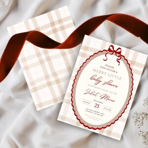 May include: Baby shower invitation with a plaid background and a red scalloped border. The invitation reads "Merry Little Baby Shower" and includes the date, time, and honoree's name. A red ribbon accents the top.