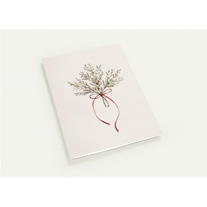 Peut inclure: Une carte de vœux avec une illustration à l'aquarelle d'un bouquet botanique noué avec un ruban rouge. Le bouquet présente des feuilles vertes et de petites baies rouges. La carte a un fond rose pâle.