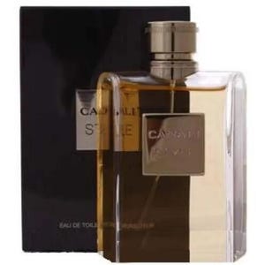 Puede incluir: Un frasco de perfume rectangular con tap&oacute;n dorado y cuerpo de cristal transparente y marr&oacute;n oscuro. El frasco tiene una etiqueta dorada con el nombre de la marca "Cadal&igrave;" y el nombre de la fragancia "Stile". El frasco est&aacute; sobre un fondo negro.