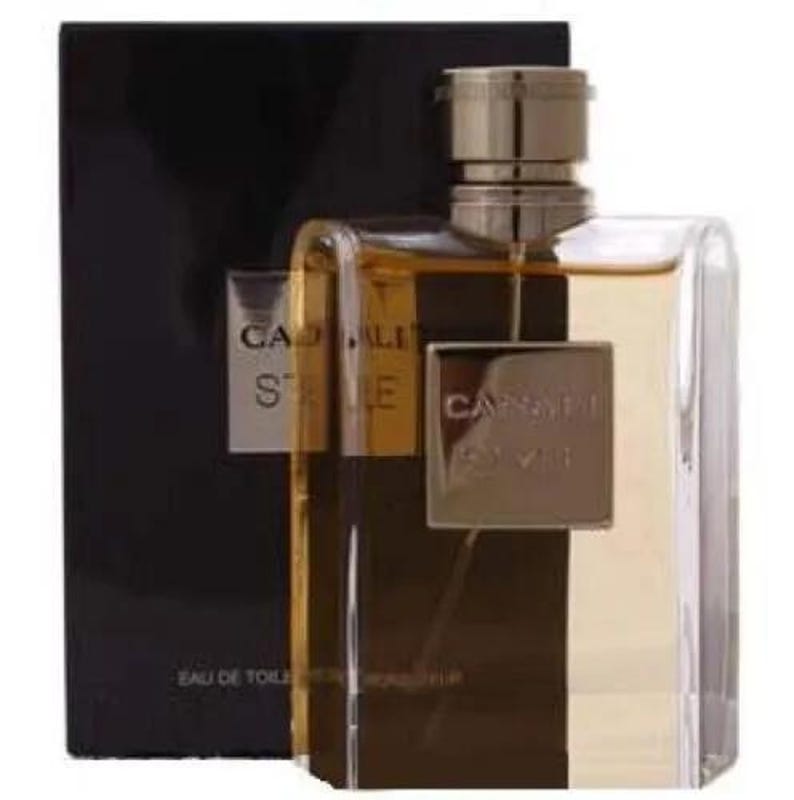 Puede incluir: Un frasco de perfume rectangular con tap&oacute;n dorado y cuerpo de cristal transparente y marr&oacute;n oscuro. El frasco tiene una etiqueta dorada con el nombre de la marca "Cadal&igrave;" y el nombre de la fragancia "Stile". El frasco est&aacute; sobre un fondo negro.