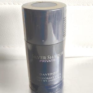 以下が含まれることがあります： ダークグレーの円筒形のデオドラントスティック。製品にはDavidoffの「Silver Shadow Private」と記載されています。正味重量は70gです。上部には円形の開口部があります。