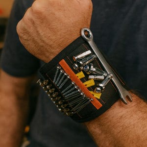May include: Black magnetic wristband with an orange stripe, holding various tools. The tools include a wrench, screws, and yellow and silver bits. The wristband is designed for easy access to tools while working.