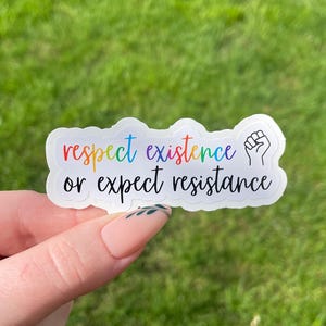 May include: A white sticker with the text "respect existence or expect resistance" in rainbow colors. A raised fist is to the right of the text.