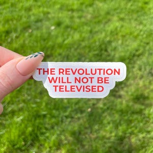 May include: White sticker with the text "THE REVOLUTION WILL NOT BE TELEVISED" in red letters.