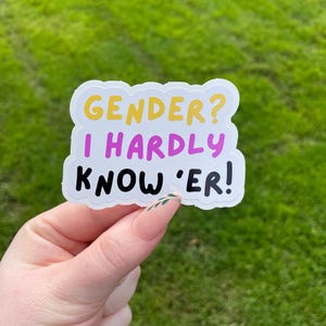 May include: White sticker with a pink, yellow, and black text that reads "GENDER? I HARDLY KNOW 'ER!"