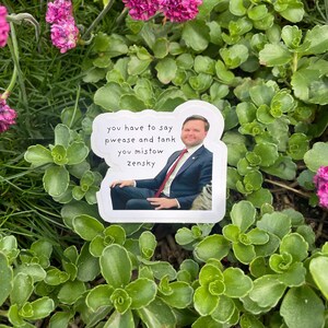 May include: A white sticker with a photo of a man in a suit and tie. The text on the sticker reads "you have to say pwease and tank you mistow zensky".