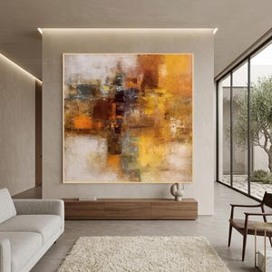May include: A large square canvas painting featuring an abstract composition with layered textures in shades of warm yellow, deep orange, dark brown, and muted gray. The artwork displays a blend of vertical and horizontal brushstrokes.