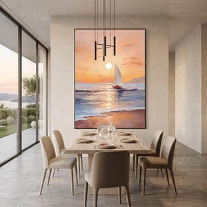Op de afbeelding: Een groot ingelijst canvas schilderij toont een zonsondergang boven de oceaan met een zeilboot. Het kunstwerk gebruikt warme kleuren, waaronder oranje, geel en rood, met een zwart frame. Het schilderij hangt boven een houten eettafel met zes stoelen.