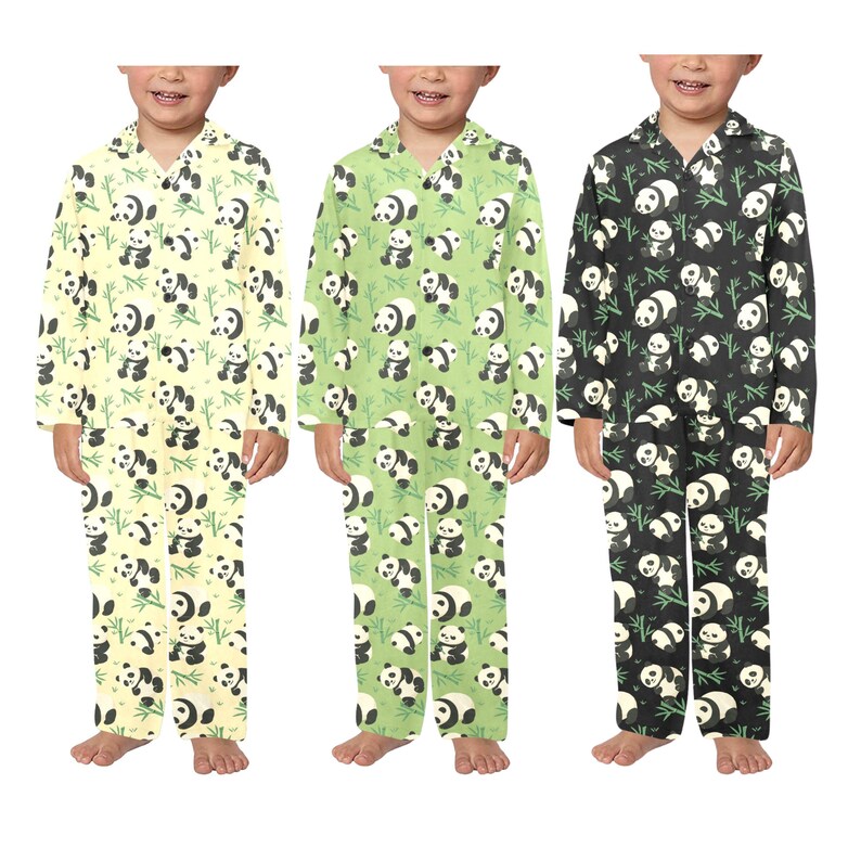 Puede incluir: Tres conjuntos de pijamas infantiles en amarillo p&aacute;lido, verde claro y negro. Cada conjunto presenta un patr&oacute;n repetido de pandas y tallos de bamb&uacute;. Los pijamas tienen mangas largas y pantalones.