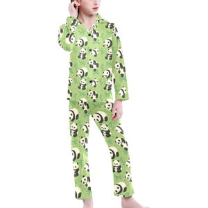 Puede incluir: Conjunto de pijama verde con un estampado repetido de osos panda y tallos de bamb&uacute;. La parte superior de manga larga tiene una parte delantera abotonada y un cuello con muescas. Los pantalones a juego tienen una cintura el&aacute;stica. El pijama est&aacute; hecho de un material suave y c&oacute;modo.