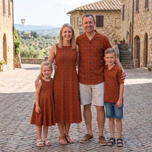 Peut inclure: Une famille de quatre personnes portant des vêtements assortis de couleur rouille avec un motif géométrique répétitif. Le groupe comprend deux adultes et deux enfants, vêtus de robes sans manches, d'une chemise à boutons et d'une chemise à col.