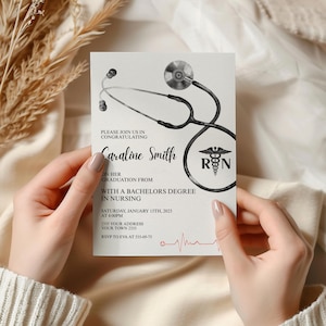 May include: A graduation announcement card held by hands. The card features a stethoscope illustration and the text "Caraline Smith" with details about her Bachelor's degree in Nursing, including the date, time, and location of the event.